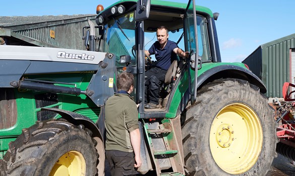 a couple of men standing next to a tractor